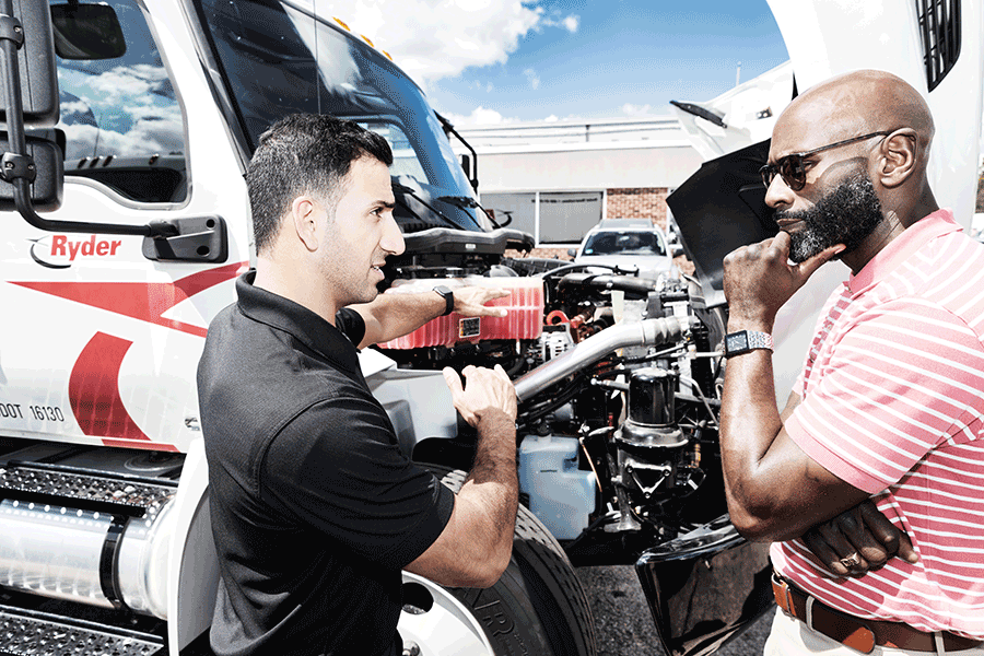 Customer observing truck engine with Ryder employee