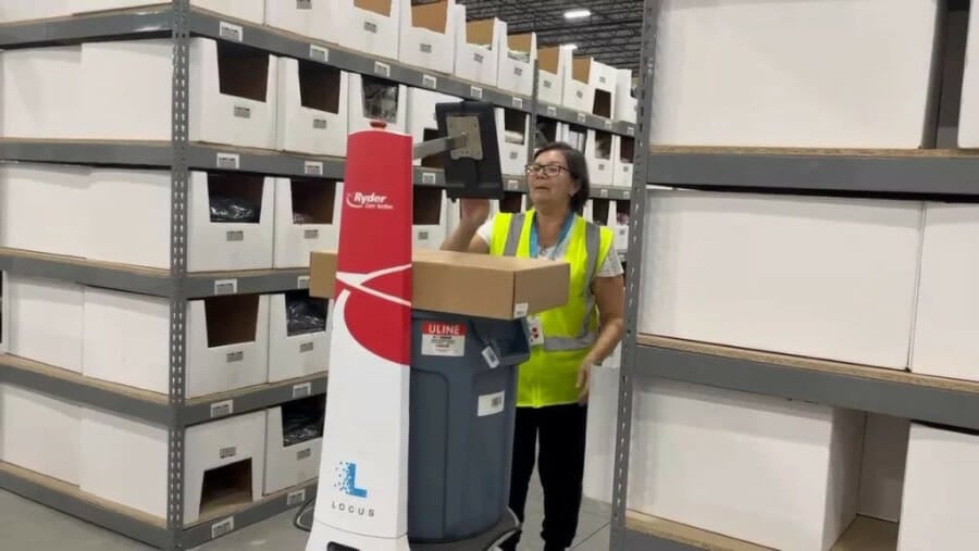 A Ryder E-commerce by Ryder employee using a locusbot to fulfill orders.