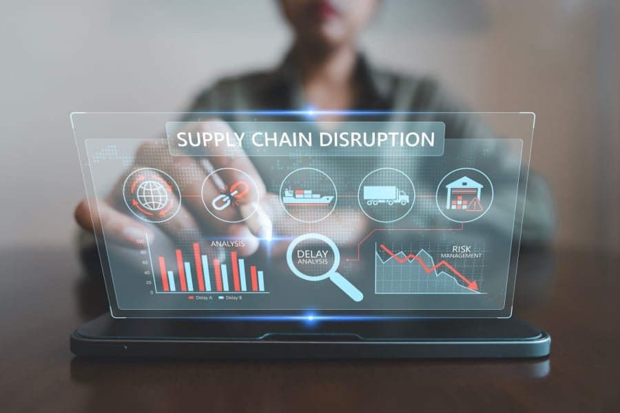 Business analyst monitoring virtual supply chain disruption dashboard.