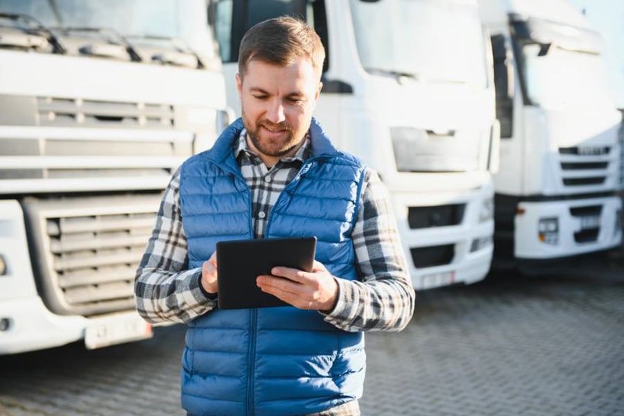 Fleet manager with tablet checking truck fleet operations