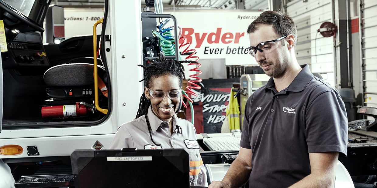 Two Ryder technicians servicing a leased semi truck