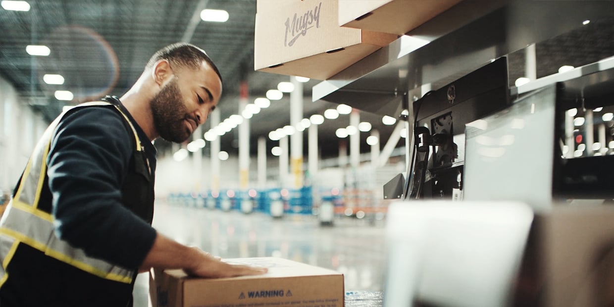 Ryder warehouse associate inspecting a package in an e-commerce fulfillment facility