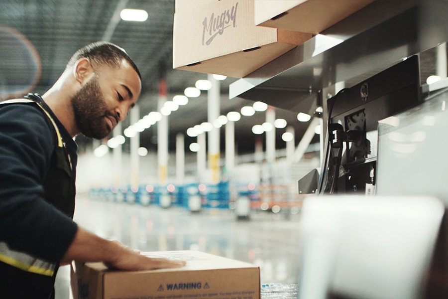 Ryder warehouse associate inspecting a package in an e-commerce fulfillment facility