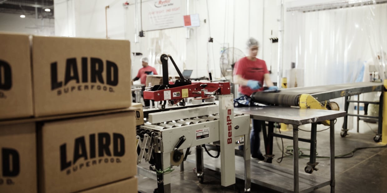 Ryder workers packing boxes on a contract packaging line in a co-packing facility