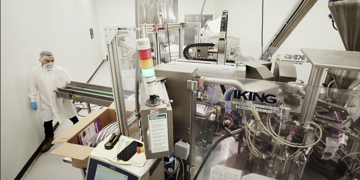 Ryder employee operating automated equipment in a contract manufacturing facility