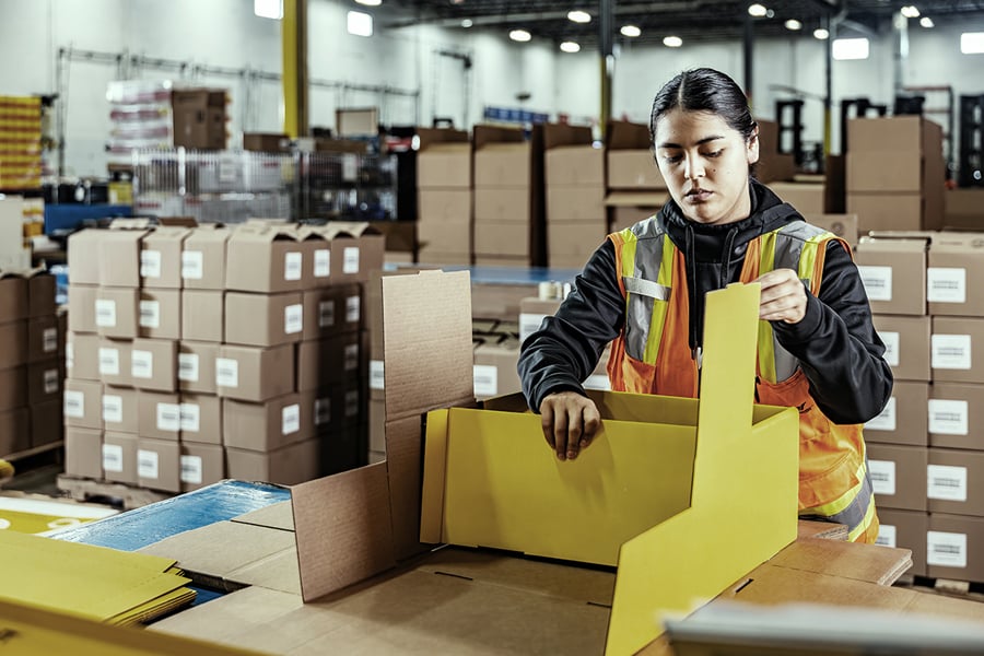 Ryder warehouse associate in a safety vest at a consumer packaged goods packing center Ryder warehouse associate in a safety vest at a consumer packaged goods packing center