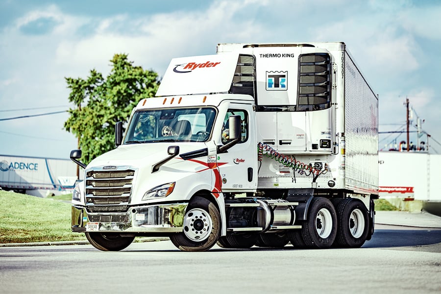 White Ryder day cab tractor with a refrigerated trailer parked in a lot White Ryder day cab tractor with a refrigerated trailer parked in a lot
