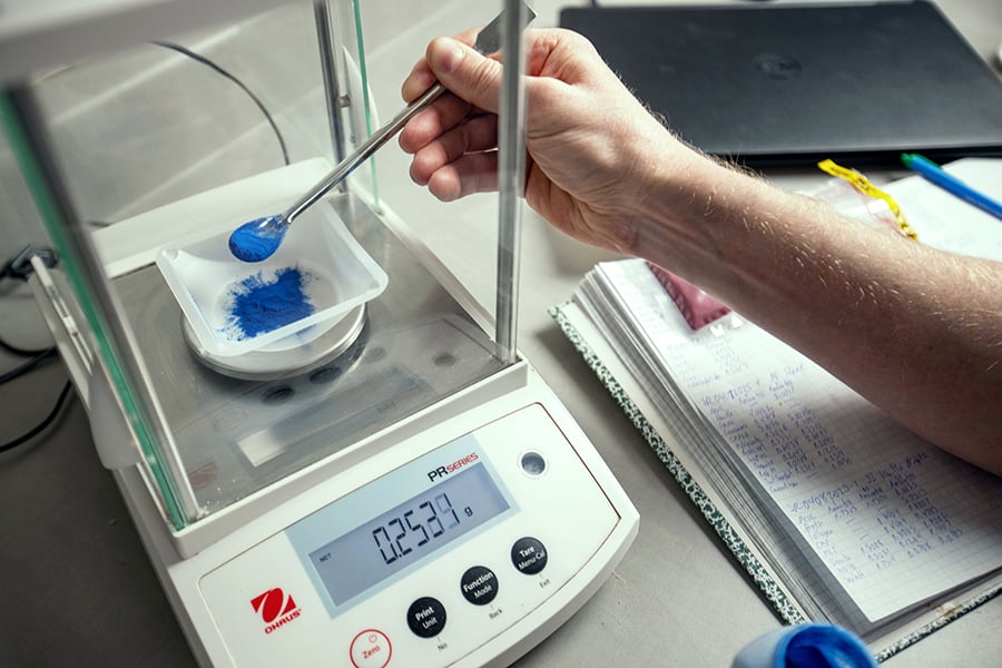 a scientist measuring powder in a lab