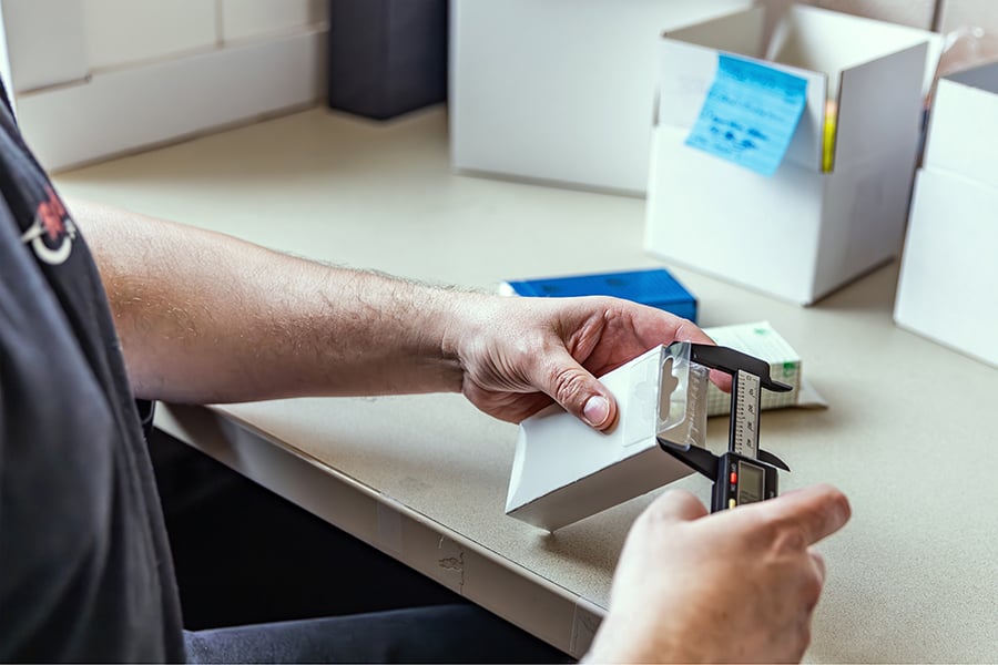 An employee measuring a small box