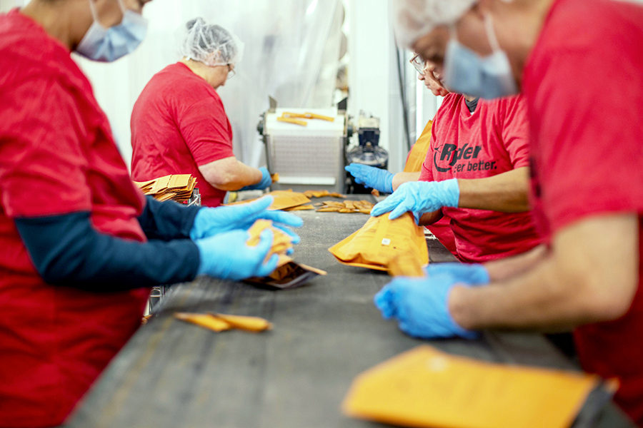 a team packing sachet packets on a table