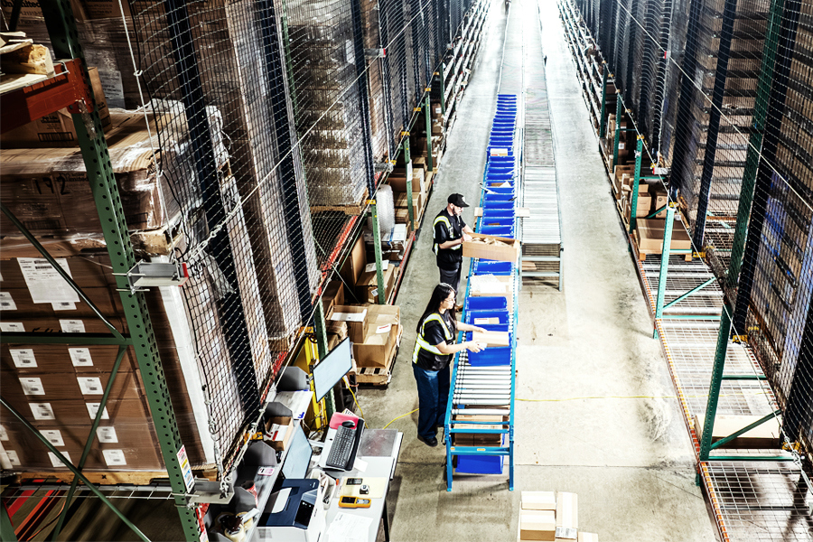 Worker using warehouse management technology to track shared warehouse inventory