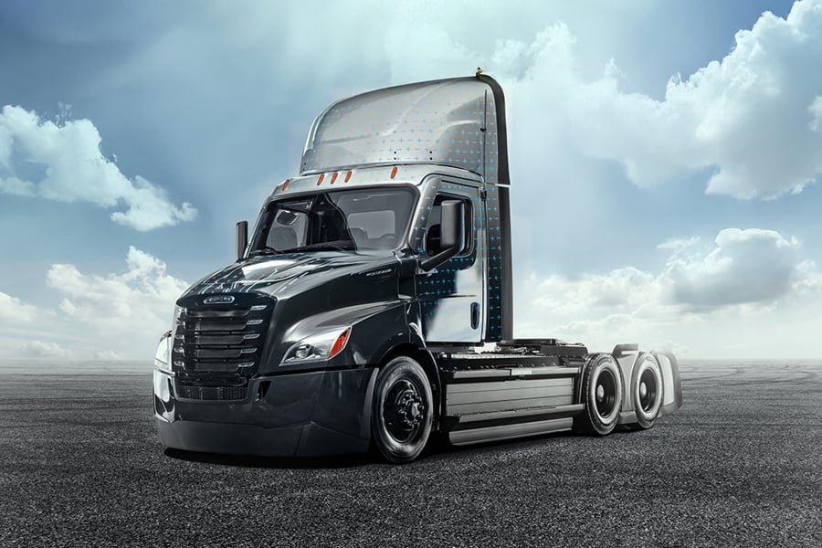 Black electric semi day cab tractor parked on pavement under a cloudy sky Black electric semi day cab tractor parked on pavement under a cloudy sky
