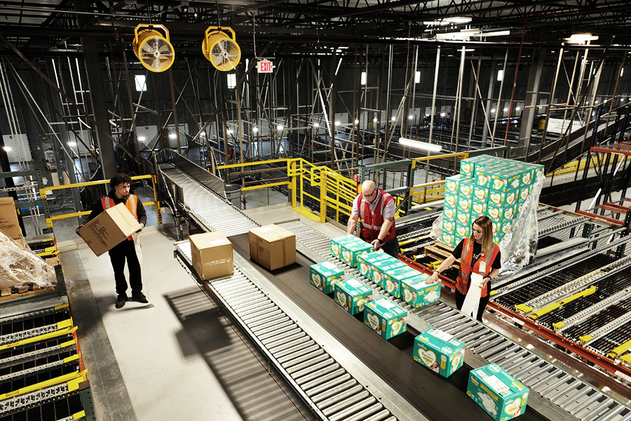 Conveyor and sortation system routing packages through a warehouse