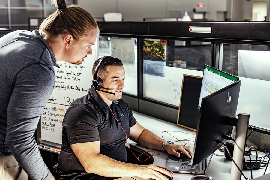 Logistics team members coordinating shipments at computer workstations in an office