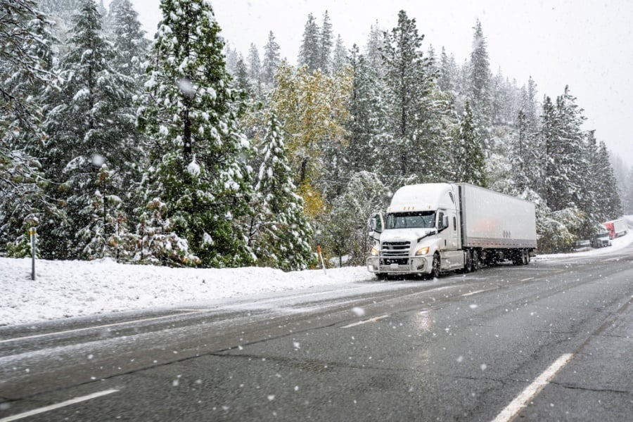 Winter Fleet Maintenance Semi-truck driving through snow and winter conditions.
